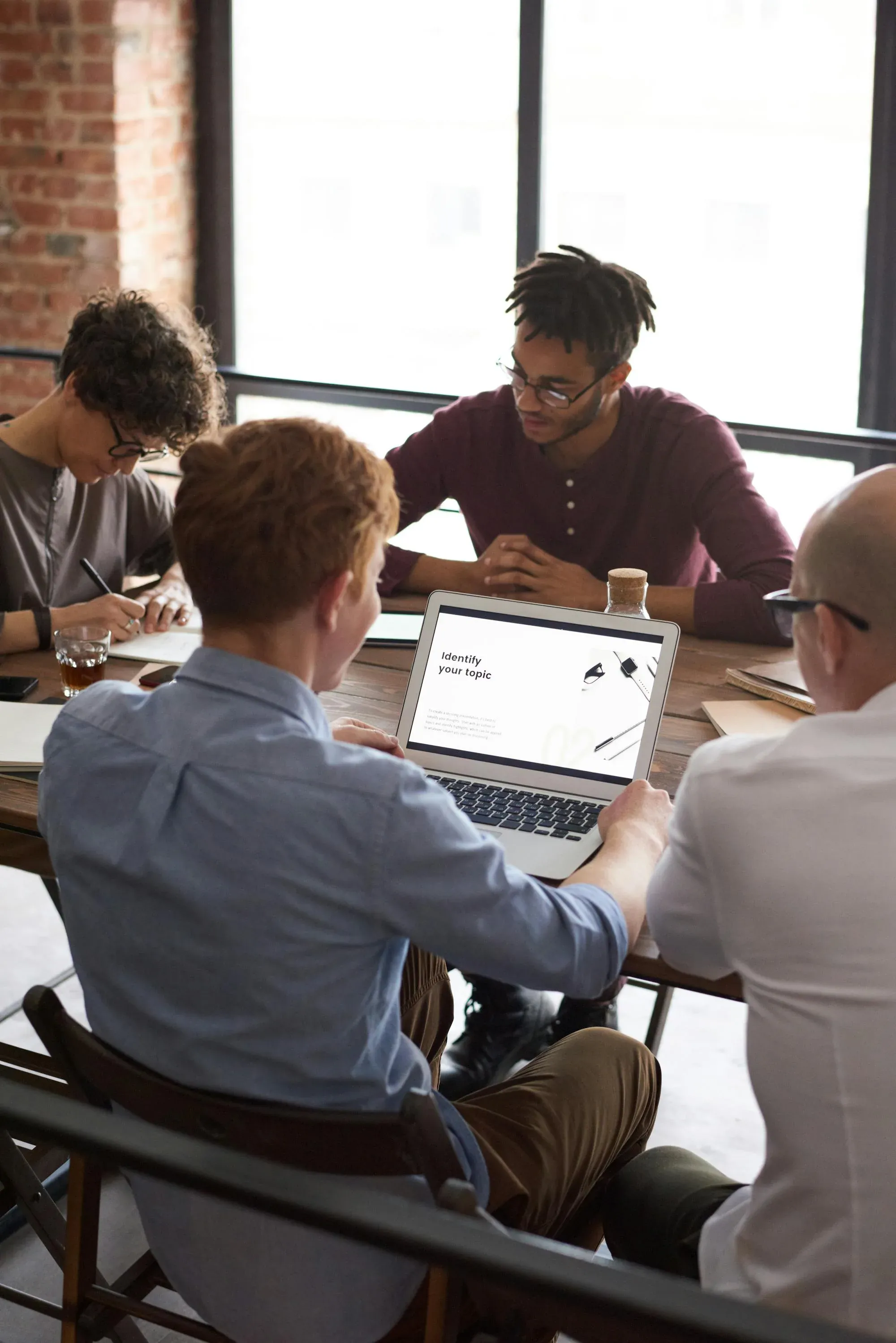 A diverse team collaborating around laptops in a bright office